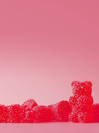 Sweet candies for happiness concept. Red jelly bears with sugar crystals on yellow background. 3d rendering illustration.の写真素材