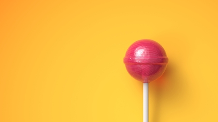 Sweet lollipop on bright yellow background with copy spaceの写真素材