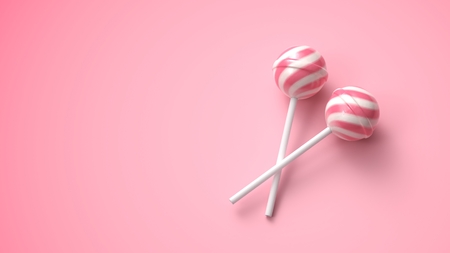 Two sweet striped pink and white lollipops on stick on bright pink backgroundの写真素材