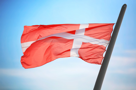 The Danish flag against the background of the blue skyの写真素材