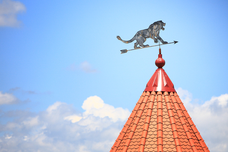 Weather vane with the image of a lion against the background of the blue skyの写真素材
