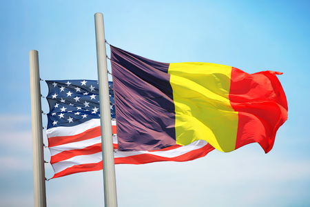 Flags of Belgium and the USA against the background of the blue skyの写真素材