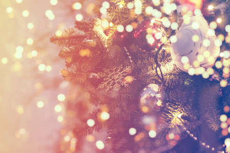 Christmas tree branch with christmas balls and lights, soft focus. Blurred lights background for your ad, poster, bannerの写真素材