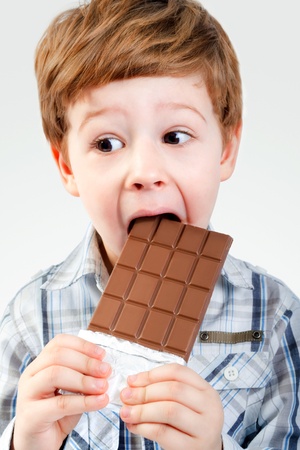 Close Up of Young Boy Eating A chocolate bar の写真素材