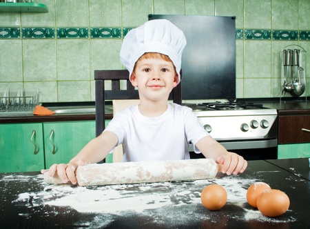 Baker, little cute child playing like baker in kitchen の写真素材