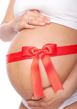 Beautiful young pregnant woman with ribbon  Isolated on white backgroundの写真素材