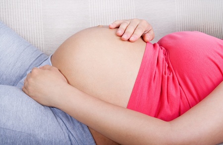 Pregnant woman lying in bed, resting の写真素材
