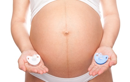 Beautiful young pregnant woman holding pacifiers