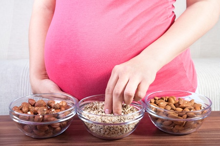 Healthy pregnancy  Pregnant woman eating different seeds の写真素材