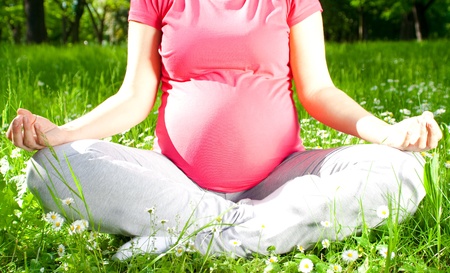 Beautiful pregnant woman relaxing in the park, yoga の写真素材