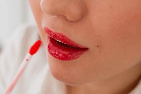 beautiful woman paints lips with lipstickの写真素材