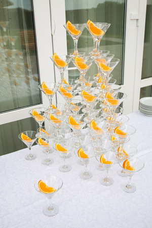 Pyramid of champagne glasses with orange slicesの写真素材