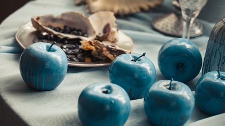 Beautifully decorated table with shells and blue apples