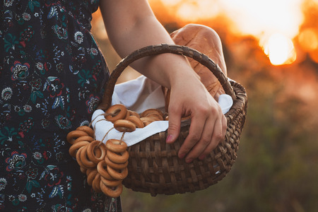 Beautiful young woman with a basket full of fresh baked bread.の写真素材