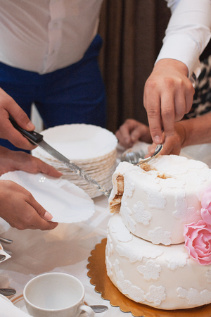 elegant pretty young bride and groom cut the wedding cakeの写真素材
