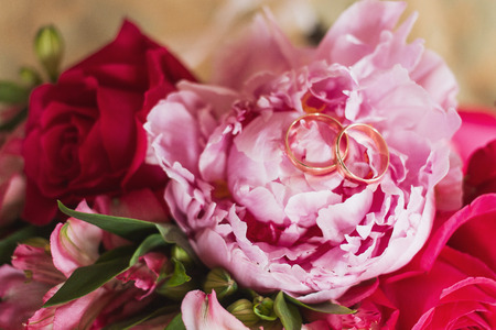 wedding rings and roses bouquet. Wedding rings on the bouquetの写真素材
