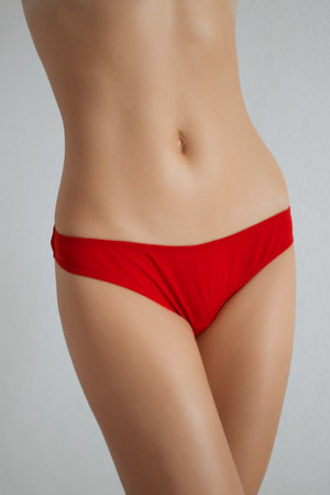 Beautiful female model with sexy back in red bikini.の写真素材