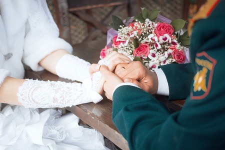 Elegant young couple standing at a reception desk with their passports with the beautiful woman smiling as she waits for serviceの写真素材
