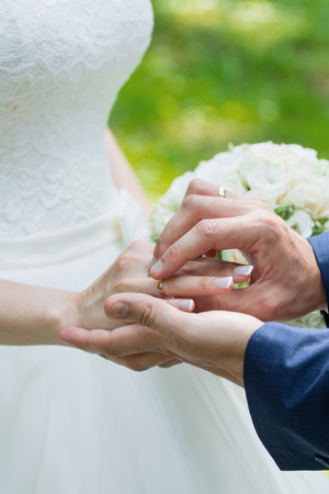 Wedding day. The groom places the ring on the bride's hand.の写真素材