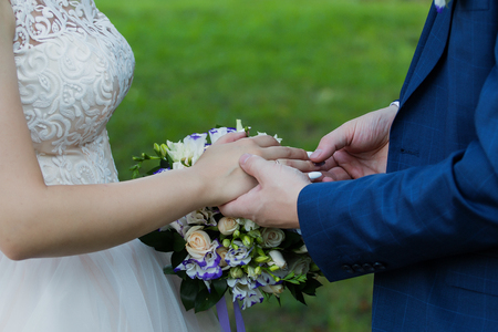 Wedding day. The groom places the ring on the bride's hand.の写真素材