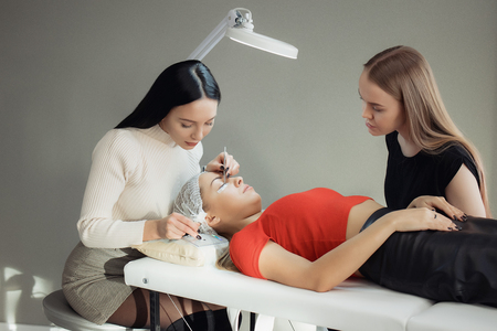 Young woman working on eyelash extensions. Woman Eye with Long Eyelashes.の写真素材