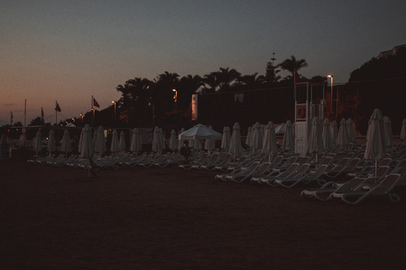 The edge Luxury swimming pool with white fashion deckchairs on the beach.の写真素材