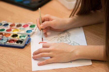 Girl paints a coloring book for adults with crayons.の写真素材