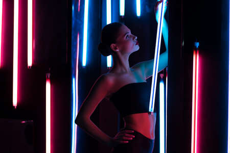 Slim woman with neon lampの写真素材
