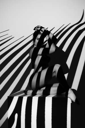 Fashion art studio portrait of elegant naked lady with shadow on her bodyの写真素材