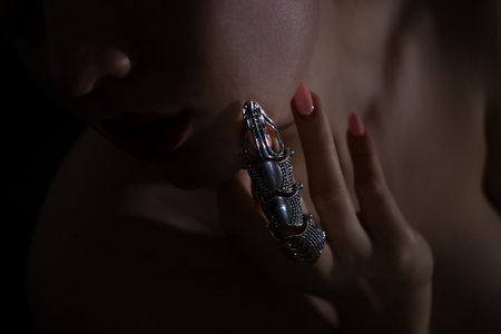 Beautiful woman with a stylish silver claw ring on her fingerの写真素材