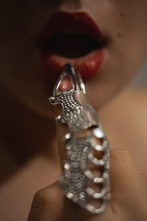 Beautiful woman with a stylish silver claw ring on her fingerの写真素材