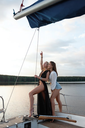 Young women on yacht at sunsetの写真素材