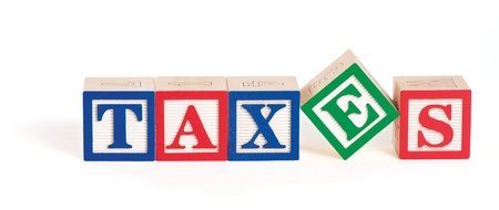 Alphabet blocks arranged to spell the word,  taxes  with the letter の写真素材
