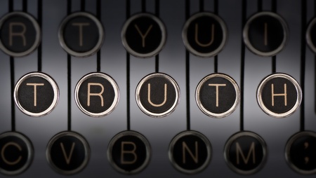 Image of old typewriter keyboard with scratched chrome keys that spell out the word TRUTH. Lighting and focus are centered on TRUTH.の写真素材