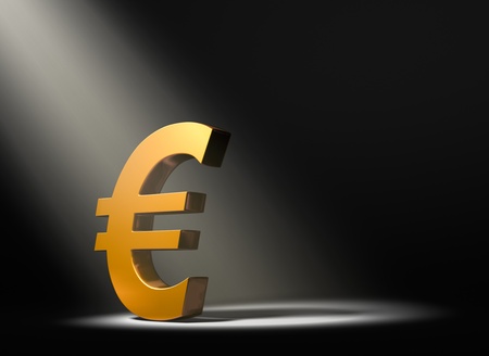 A gold Euro symbol on a black background and illuminated by a single, yellow spotlight の写真素材
