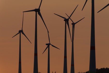 Wind engines in rural scene with setting sun