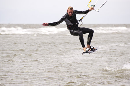ST. PETER-ORDING, GERMANY - JULY 22: Professional  kite-surfer Karsten Koschewski, Germany,  demonstrating his ability on the Palmolive Kitesurf Worldcup 2010 in St. Peter-Ording, July 22, 2010 in St. Peter-Ording, Germanyのeditorial素材