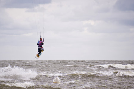 ST. PETER-ORDING, GERMANY - JULY 24: Professional kite-surfer demonstrating his ability on the Palmolive Kitesurf Worldcup 2010 in St. Peter-Ording, July 24, 2010 in St. Peter-Ording, Germanyのeditorial素材