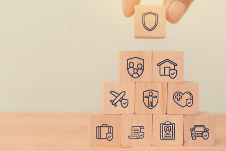 insurance concept, wooden cube symbolize put the insurance to protect or cover person,  car, life, business, health, house, legal expenses, travel, Property ,Liability, reliability, vintage styleの写真素材