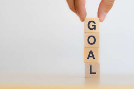 Hand arranging wooden cube block the word GOAL. Business growth conceptの写真素材