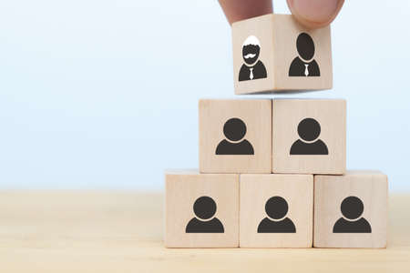 business hand man put arranging on wooden cube block that family or company Succession business concept from old generation to next generation.の写真素材