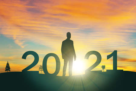 silhouette man look to target the mountain  to 2021 years with the sunset or sunrise background. Happy and success growth with new year 2021 conceptの写真素材