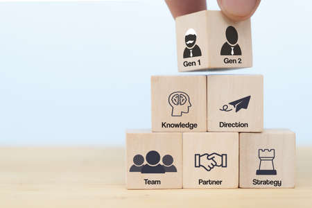 business hand man put arranging on wooden cube block that family or company Succession business concept from old generation to next generation. transfer Knowledge, Direction, Team, Partner, Strategyの写真素材