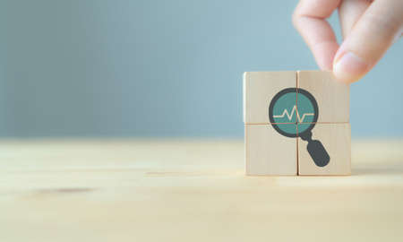 Annual medical health check up healthcare concept. Digital health check. Medical or health insurrance business. Hand puts the wooden cubes with health check up  icon on grey background and copy space.の写真素材