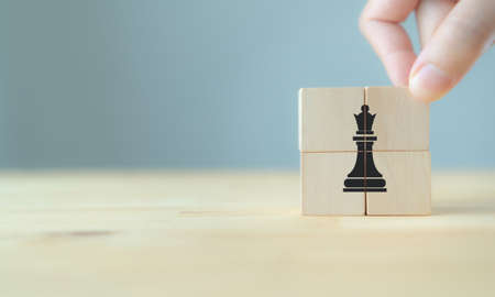 Success business strategy concept. Change and strategy management for business adaptation. Hand put the wooden cubes with chess icon on beautiful grey background and copy space. Game changing concept.の写真素材