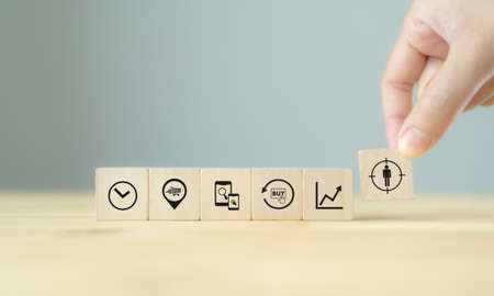 Contextual marketing concept. Customer behavior data analysis. Personalized marketing strategy with data driven. Hand holds wooden cubes with personalization icon standing with customer behaviors.の写真素材