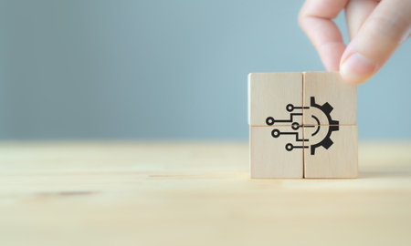 Emerging and futuristic technology concept. Working by tech. Hand put the wooden cubes with digital technology gear icon on grey background and copy space. Digital disruption and transformation.の写真素材