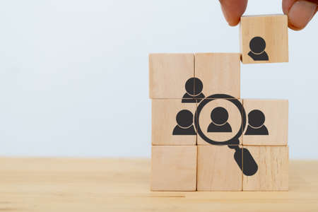 Human resources and recruitment concept. Employment headhunting concept. Choice of an employee leader from the crowd. Man holds wooden cube with finding special person. Target customer. Banner.の写真素材