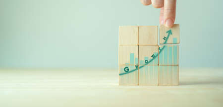 Growth and success concept.  Business common goal setting and strategies. Hand puts wooden cubes ...