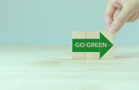 Green business. Sustainable environmental development to limit global warming and climate change. Sustainability business, ECO minded coporate. Wooden cubes with "GO Green" icon. World environment dayの写真素材
